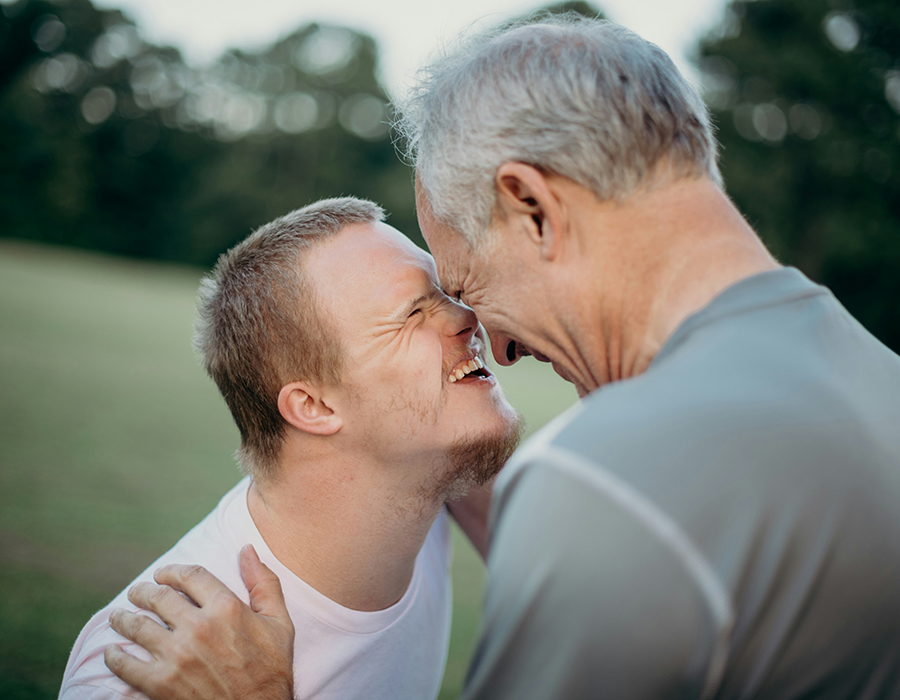 father and son smiling with foreheads together