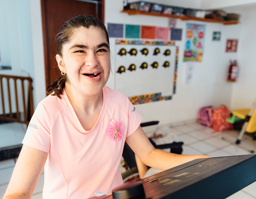 Smiling teen in pink shirt in front of communication device