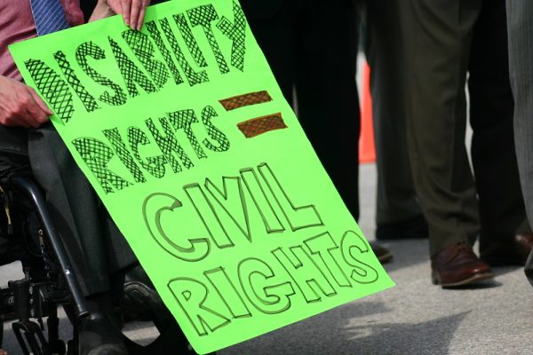 Picture of a person in a wheelchair holding a sign that says Disability Rights equal Civil Rights